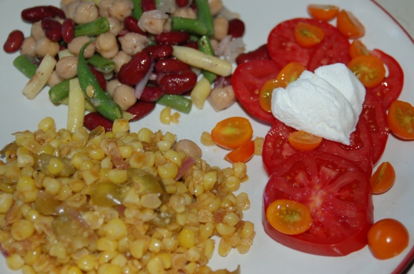 Tomatillo-corn sauté, three bean salad and sliced tomatoes with goat cheese.